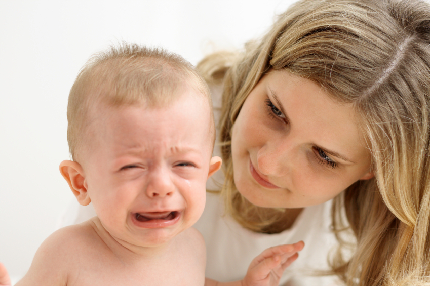 Mother calming crying baby. (stock image)