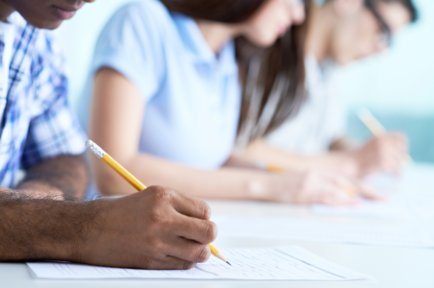 A tightly cropped photo of students writing. (stock image)