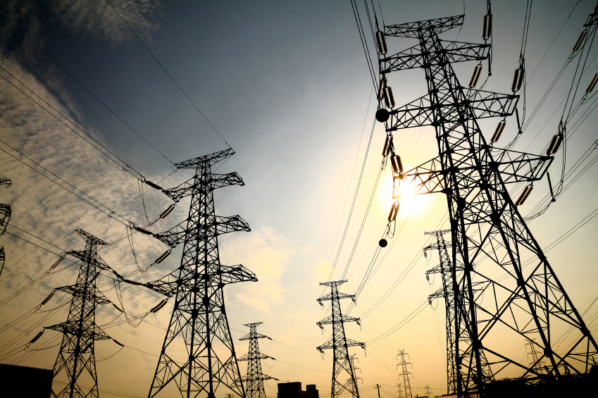 A row of transmission towers in the sunset. (stock image)