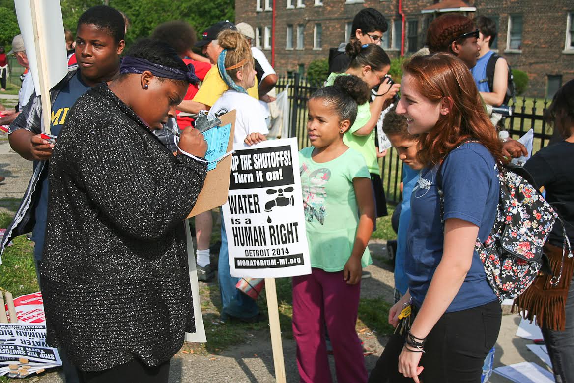 Freida Blostein, a junior evolutionary anthropology major, collects signatures at a Highland Park march and rally to stop water shutoffs. Image credit: Jared Wadley