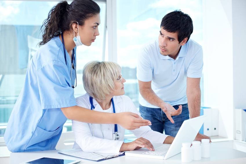 A patient, doctor, and nurse discuss a patient's electronic medical records. (stock image)