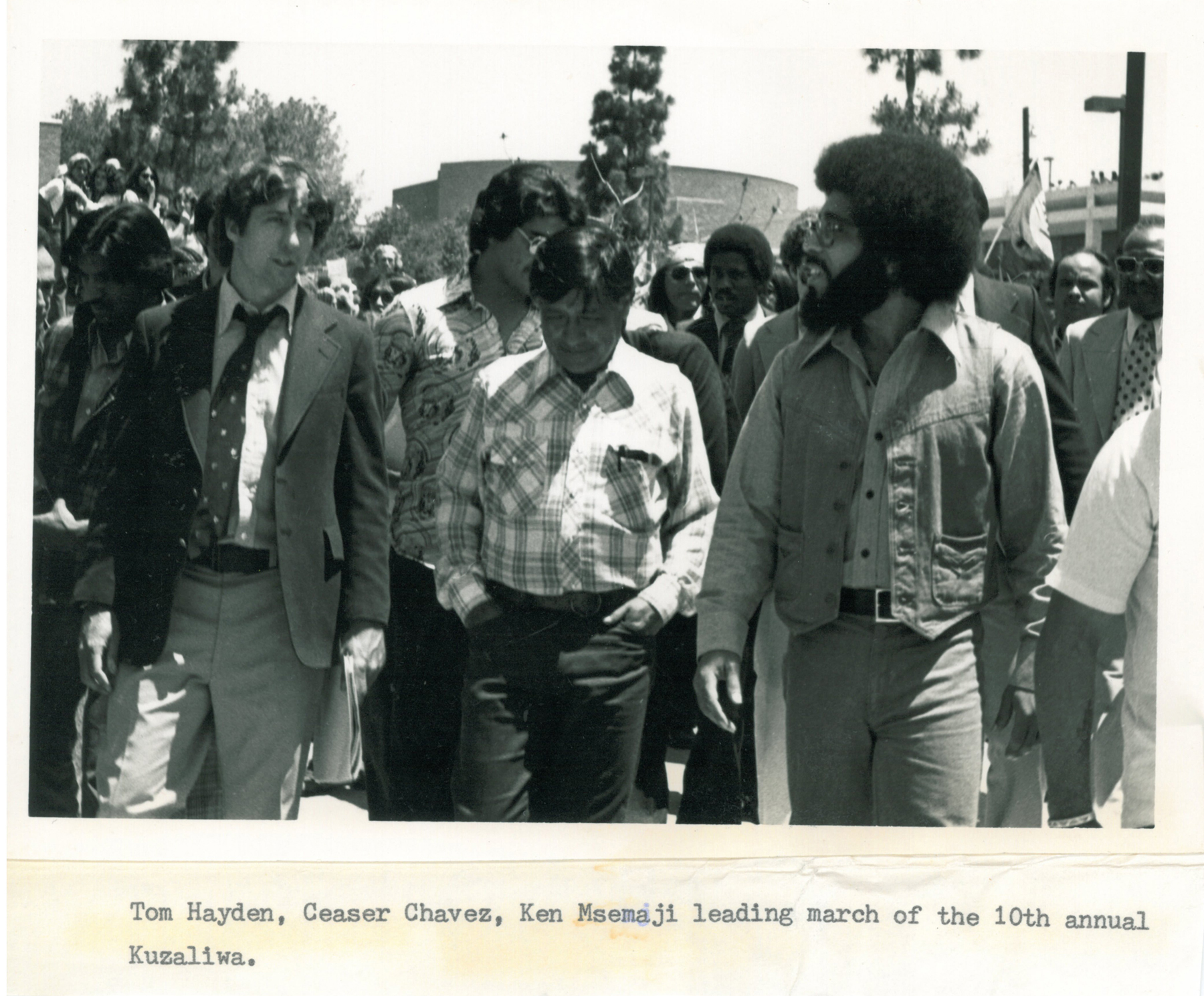 (From left): Tom Hayden, Cesar Chavez (United Farmworkers Union), and Ken Msemaji  (Nia Cultural Organization) leading the march of the 10th annual Malcolm X Kuzaliwa (birthday)   celebration, May 1977. Image credit: Tom Hayden Papers held at the University of Michigan Library