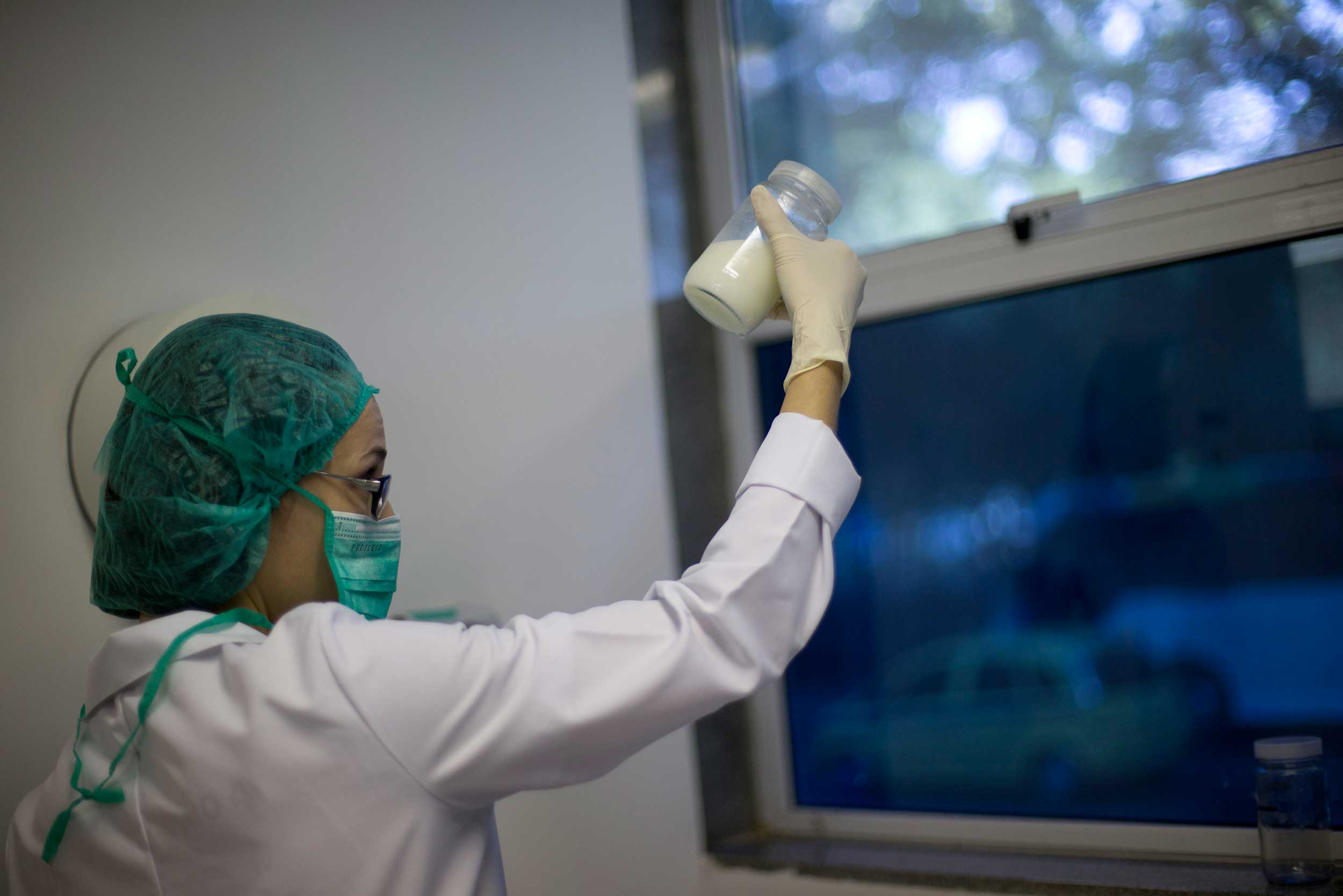 A Brazilian milk bank worker examines a donation of breast milk. (AP Photo/Silvia Izquierdo)