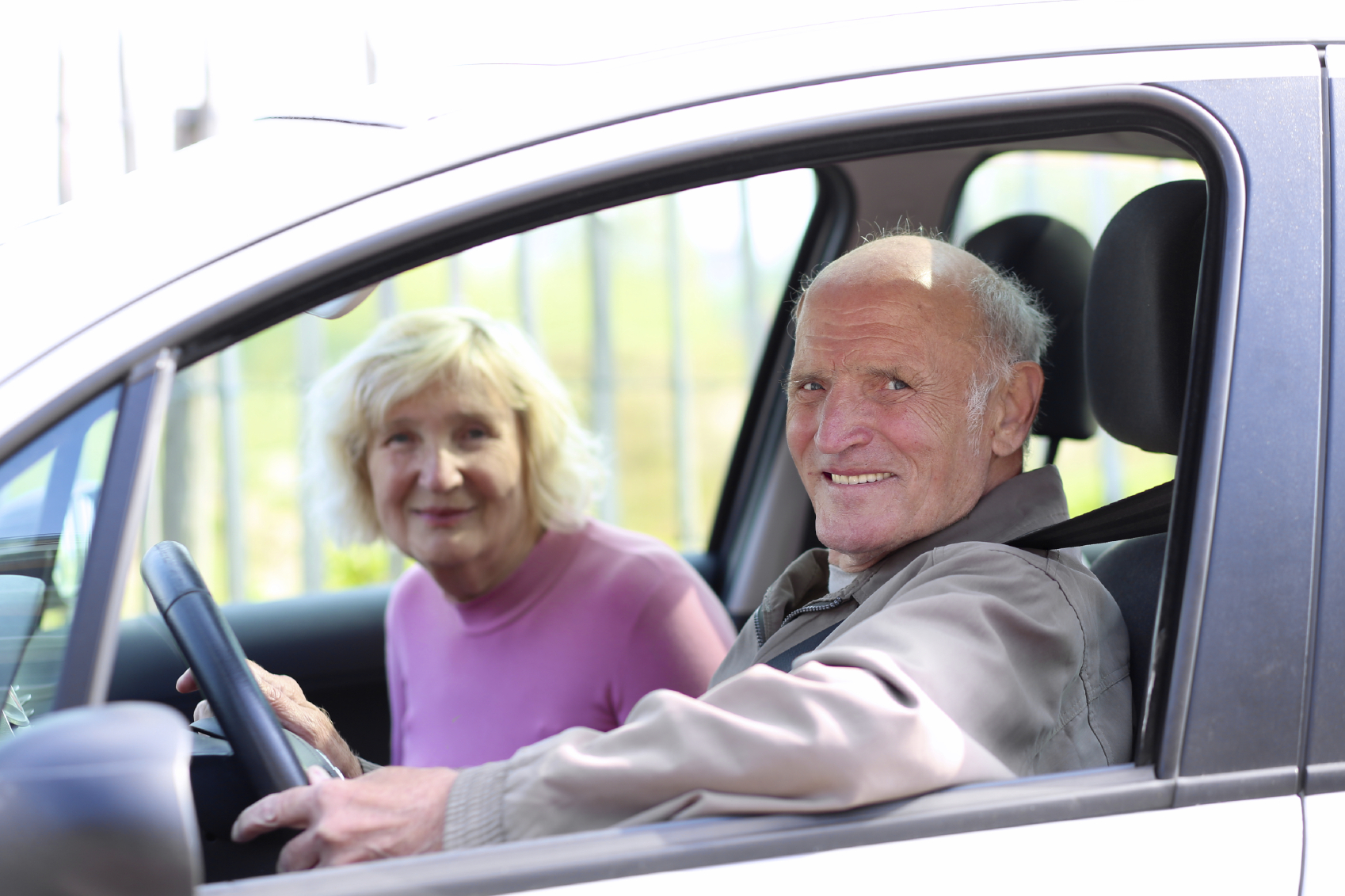 Happy senior couple driving modern car. (stock image)