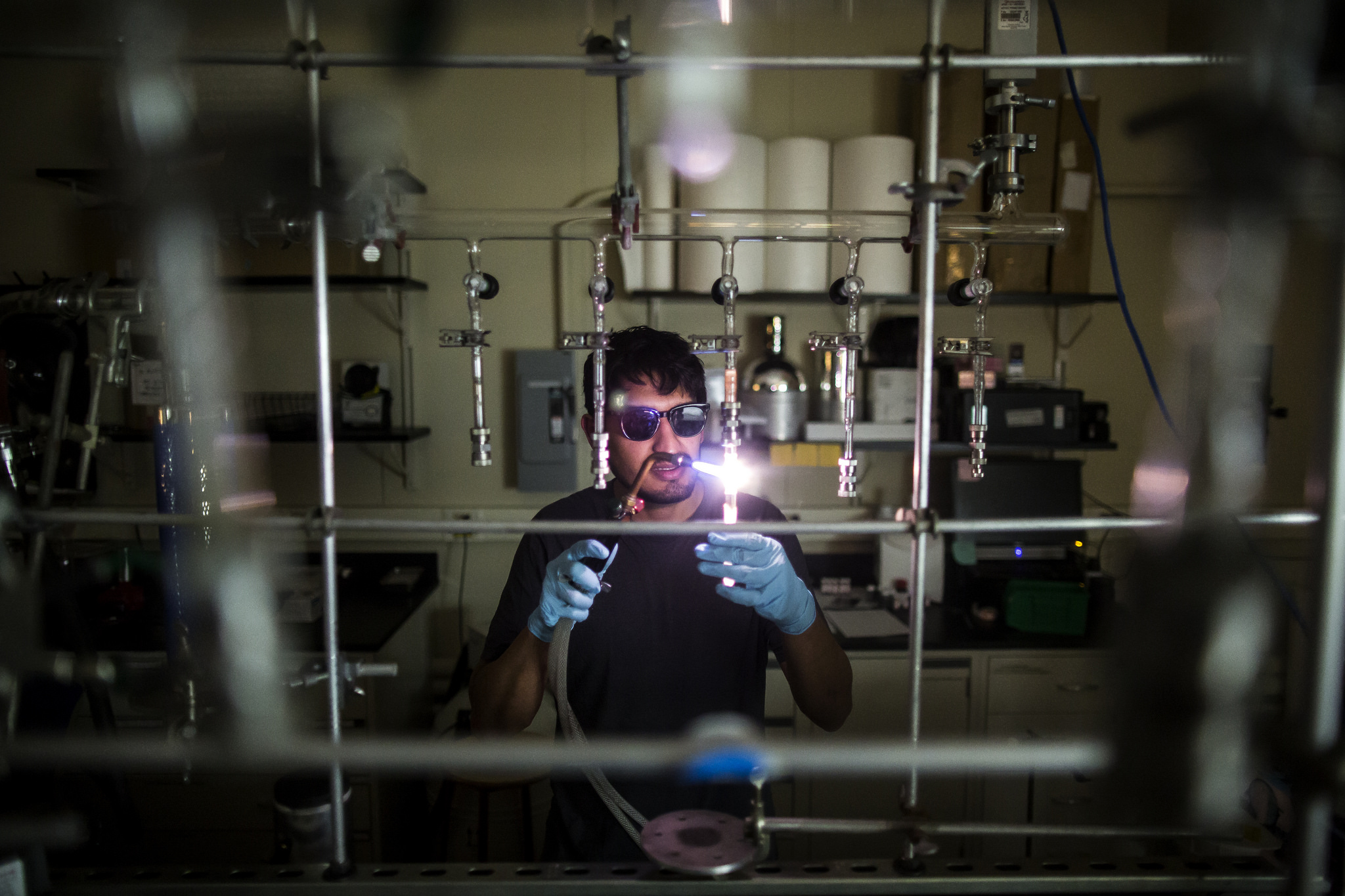 MSE PhD student Juan Lopez cuts a glass tube used in the production process for a new semiconductor compound in the HH Dow building. Image credit: Joseph Xu