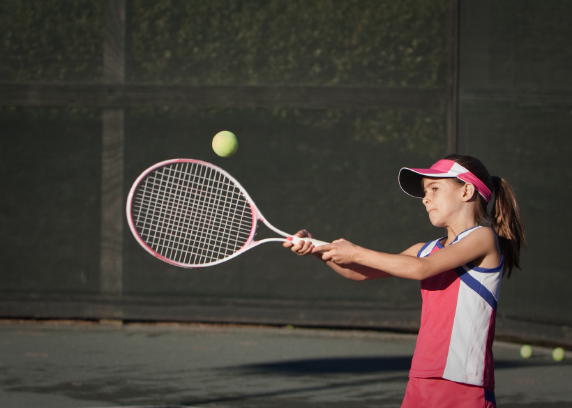 A young girl playing tennis. (stock image)