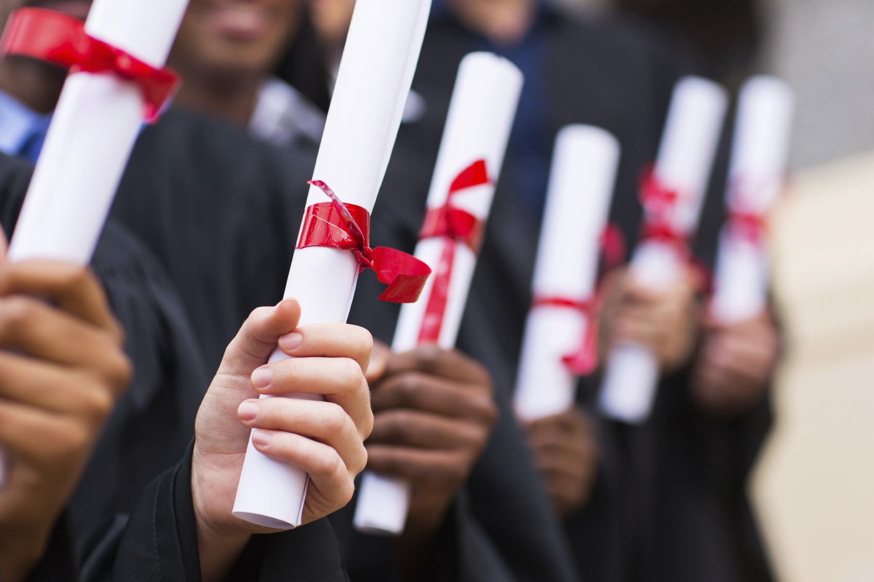 A group of graduates holding diploma. (stock image)