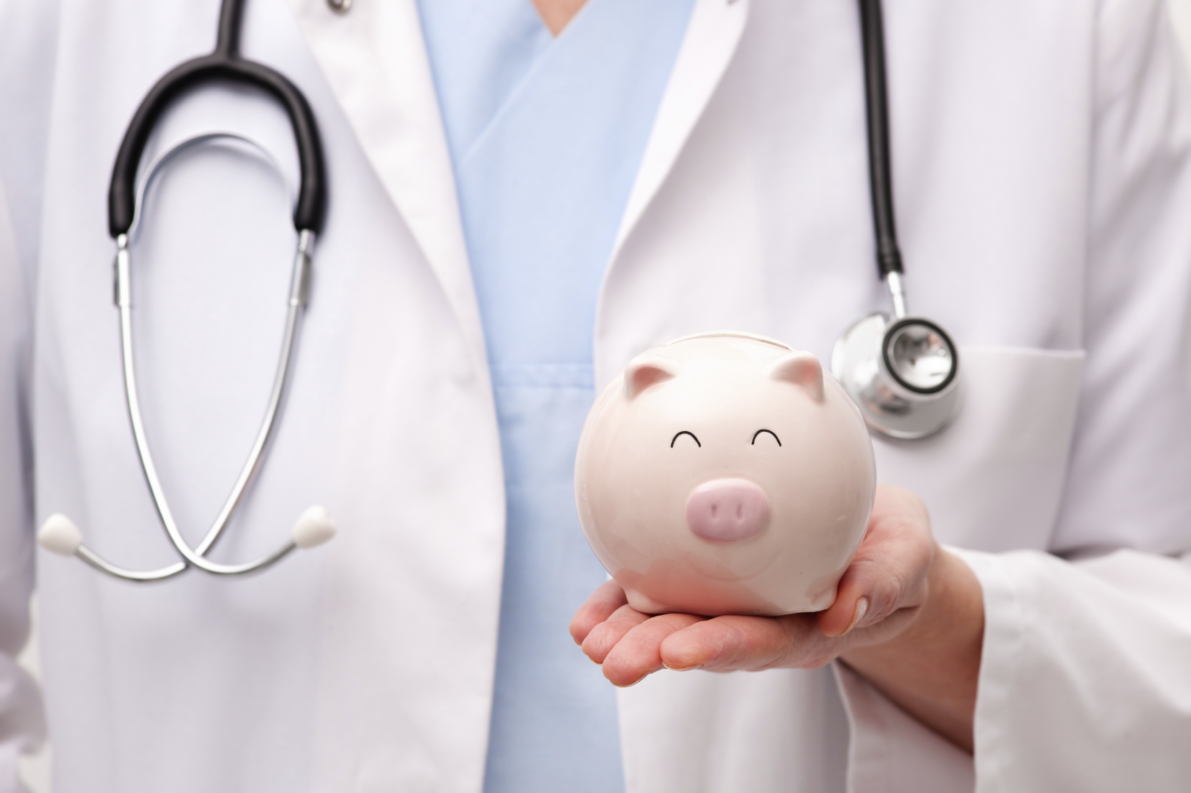 A doctor holding a piggy bank. (stock image)