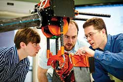 Experts examine robot hip joint.