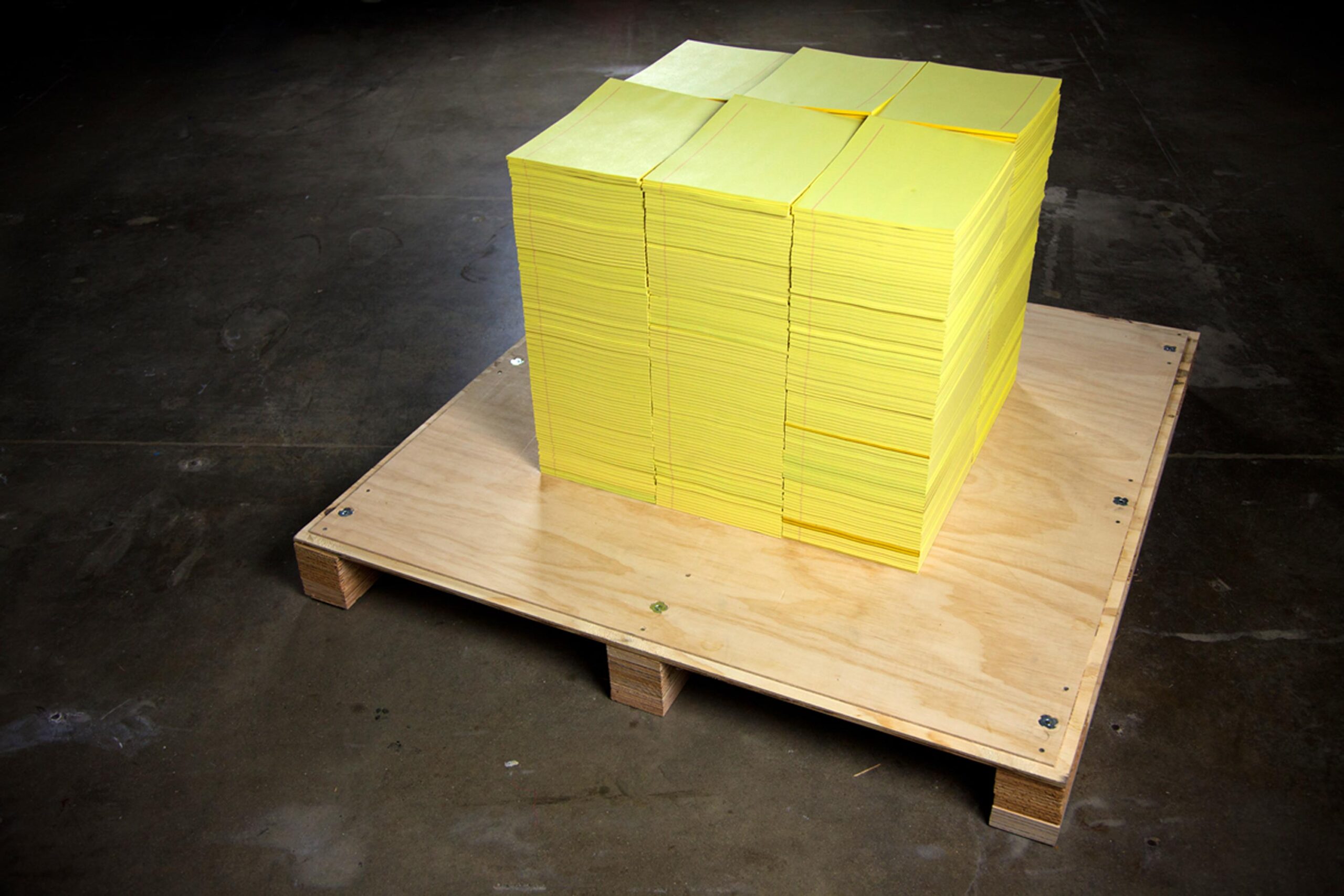 A palett of ordinary-looking legal pads disguises special notebooks printed with micro-printed text. Courtesy Matt Kenyon, SWAMP (Studies of Work Atmospheres and Mass Production)