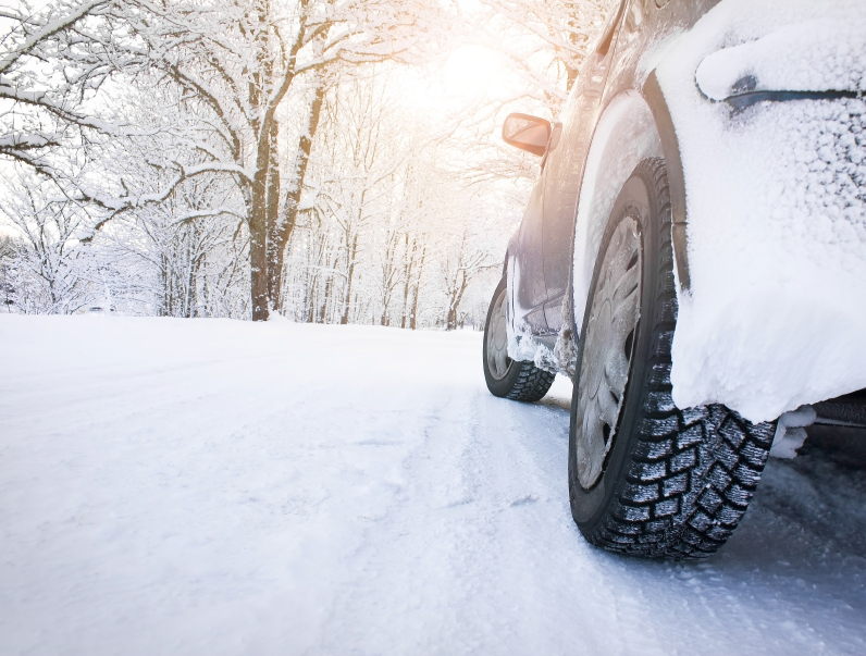 A vehicle travelling on a snowy road. (stock image)