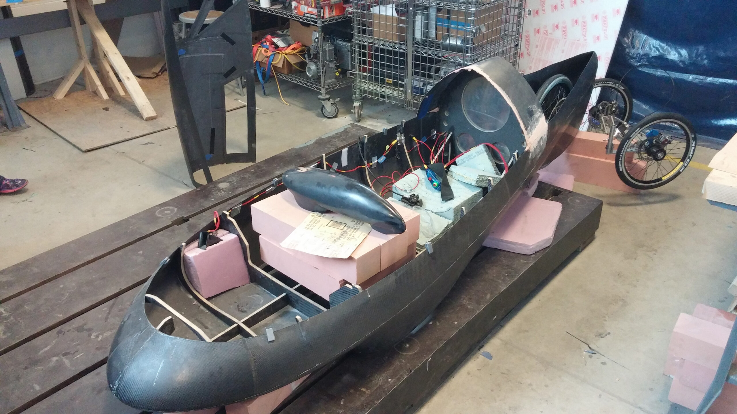 The carbon fiber body and exposed cockpit of the team’s vehicle, under  construction inside the Wilson Student Project Center. Image courtesy: Supermileage Team
