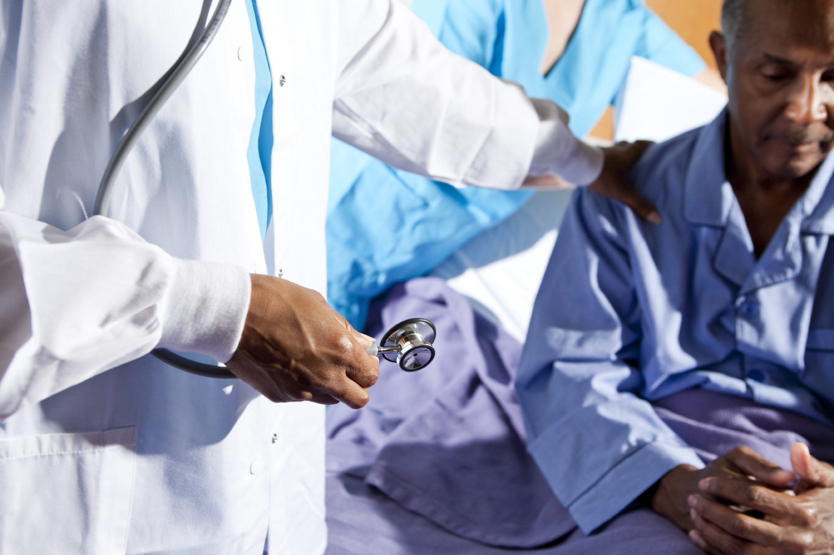 Doctor and nurse with patient in hospital bed. (stock image)