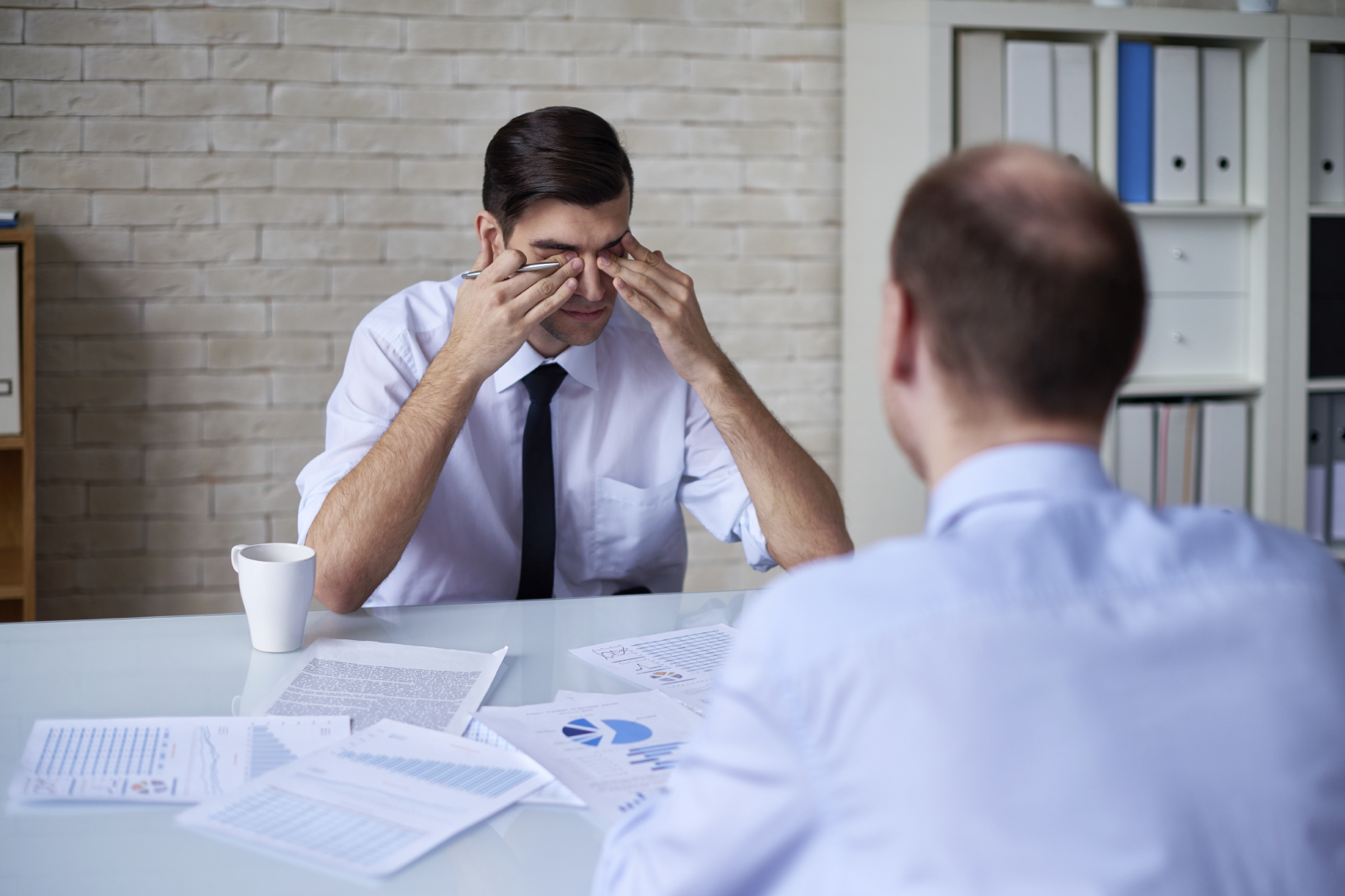 A man crying in a meeting. (stock image)