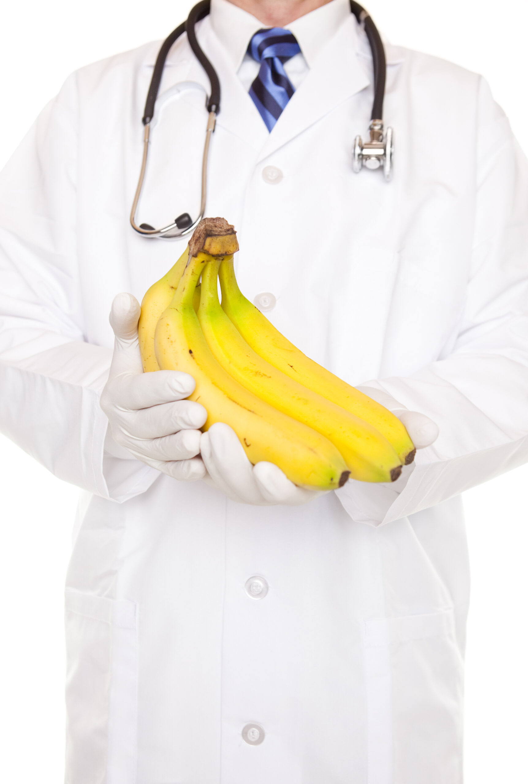 A doctor in a white coat holding a bunch of bananas. (stock image)