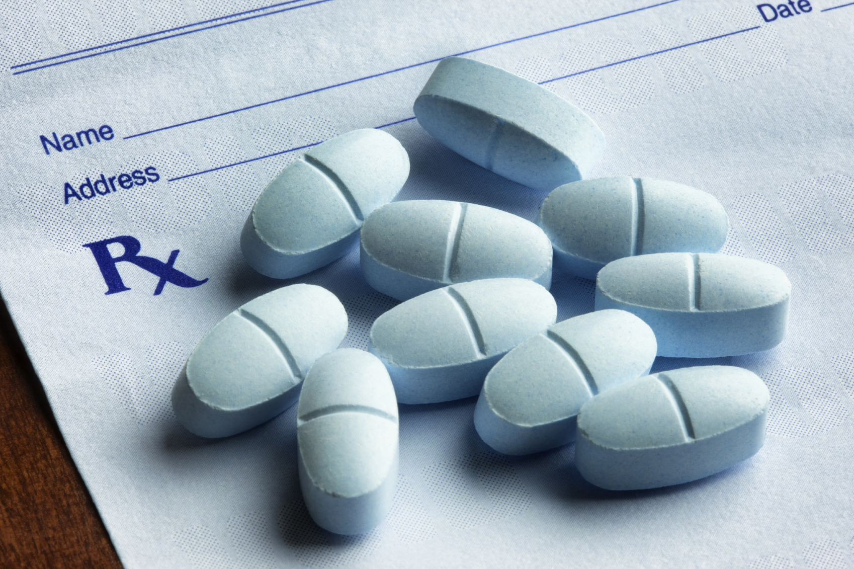 Opioid pills on top of a prescription pad. (stock image)