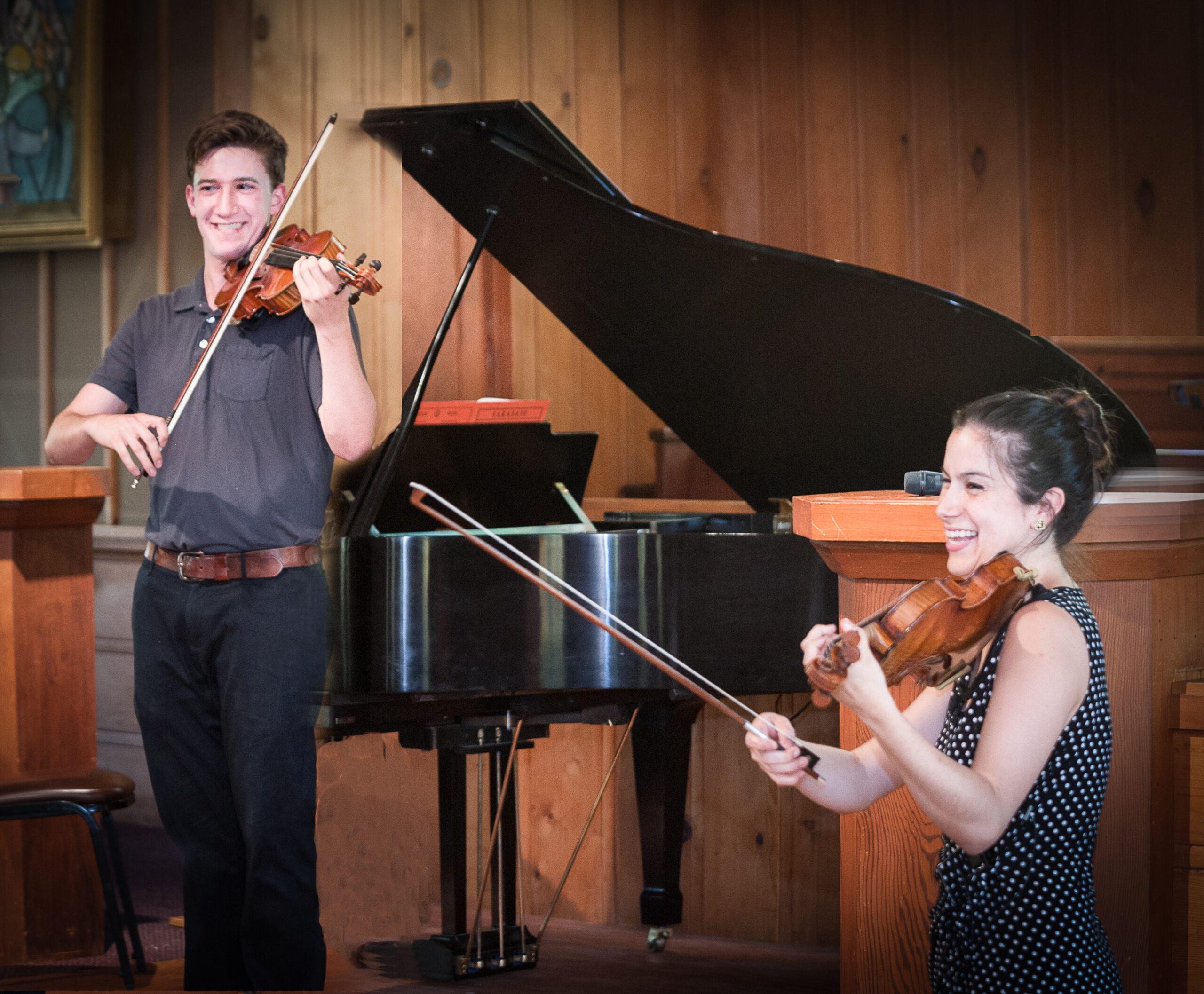 A Center Stage Strings student plays with Danielle Belen (right).