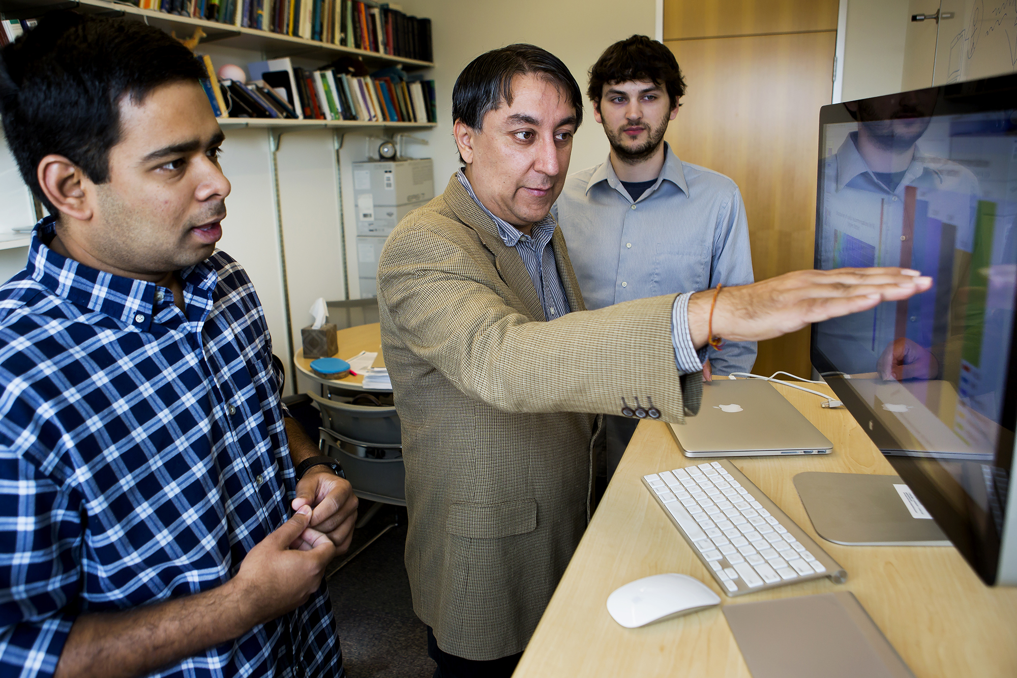 Satinder Baveja (center), University of Michigan professor of computer science and engineering, is leading a project with IBM to develop a conversational cognitive computing system that would initially serve as an automated advisor for a segment of undergrad students. Here, he discusses the project with Ananda Narayan (left) and Charles Welch (right), doctoral students and researchers in Baveja's group. Image credit: Joseph Xu