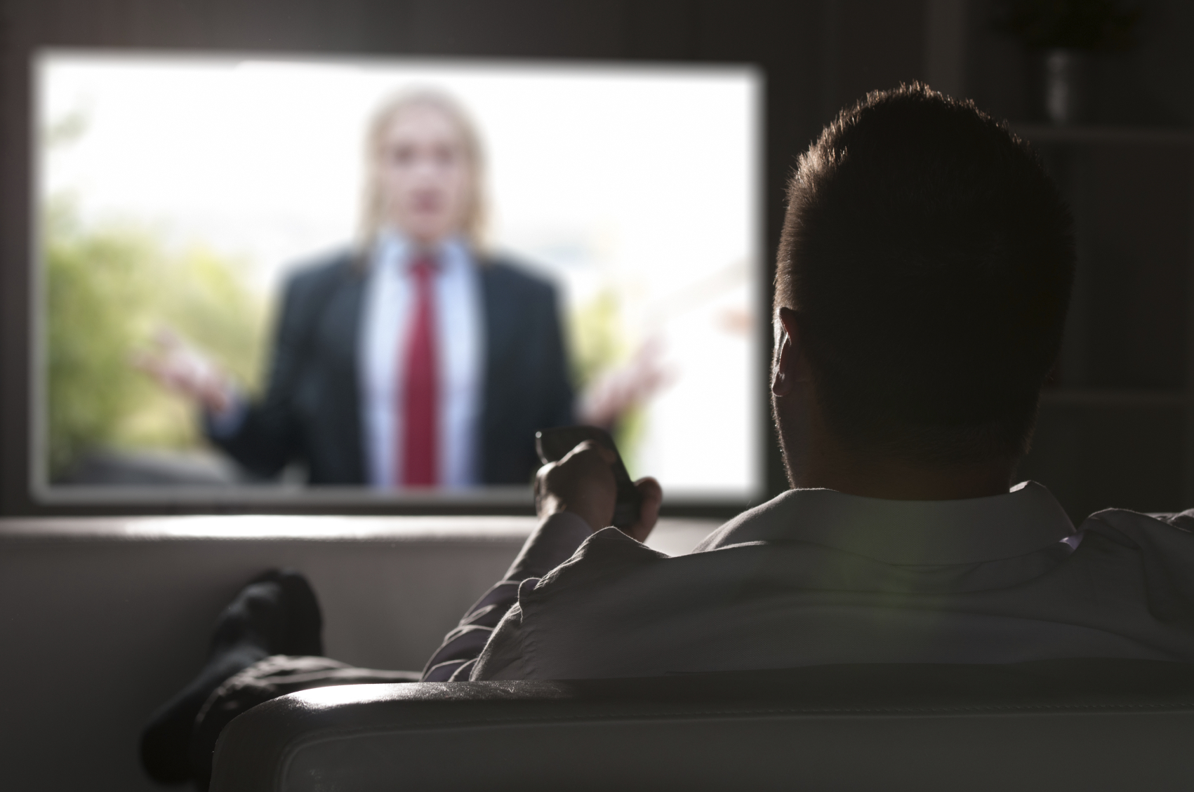 Father watching TV alone at night. (stock image)
