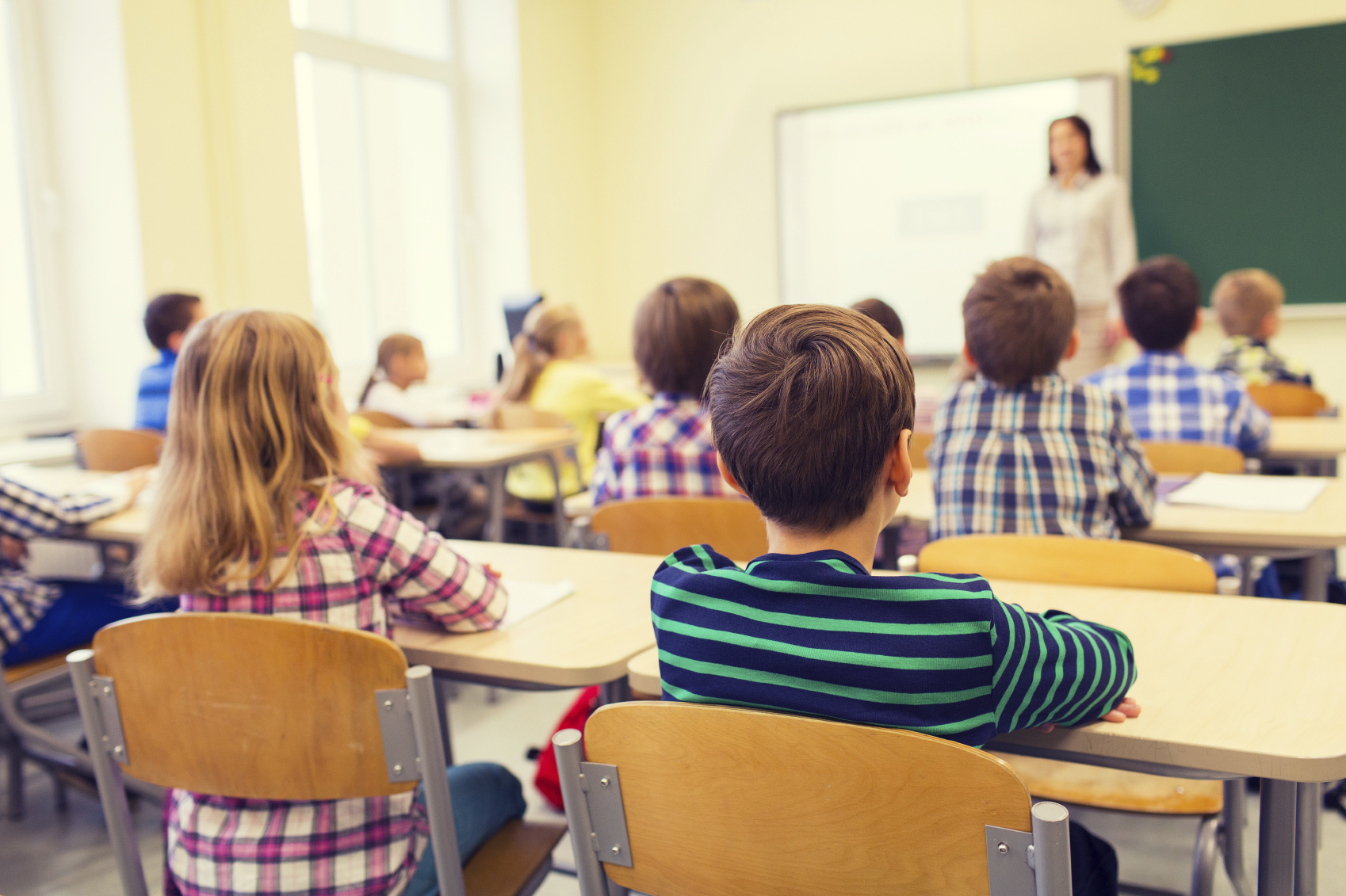 Group of school kids and teacher in classroom. (stock image)