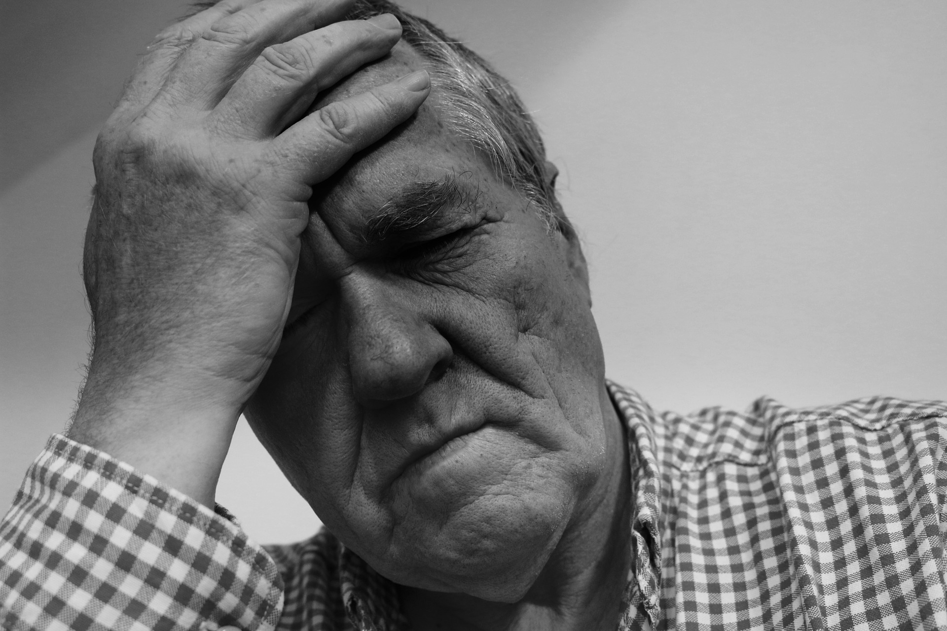 An older man with his head in his hand. Image credit: geralt via Pixababy