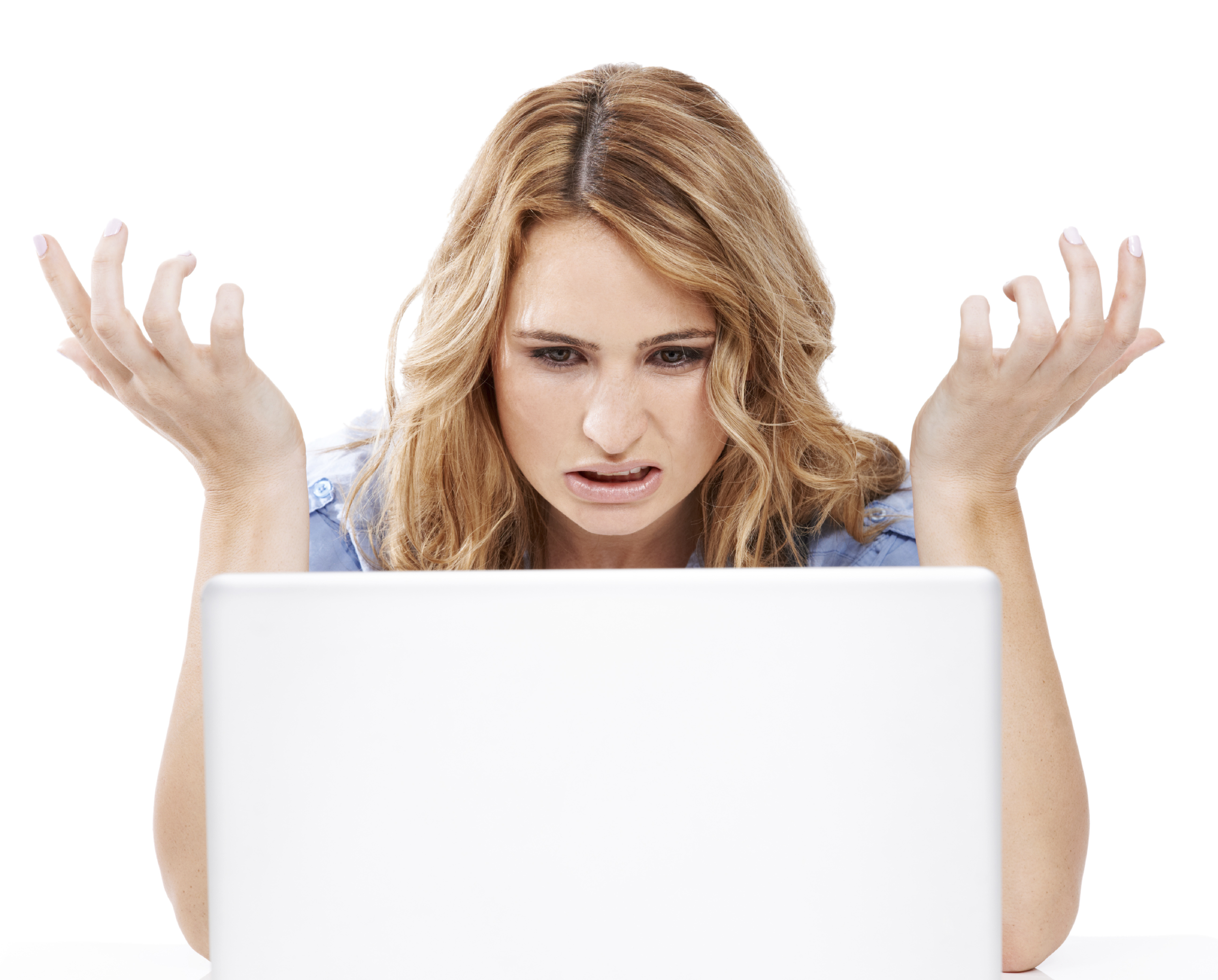A woman holds up her hands in disugust as she looks at her laptop computer screen. (stock image)