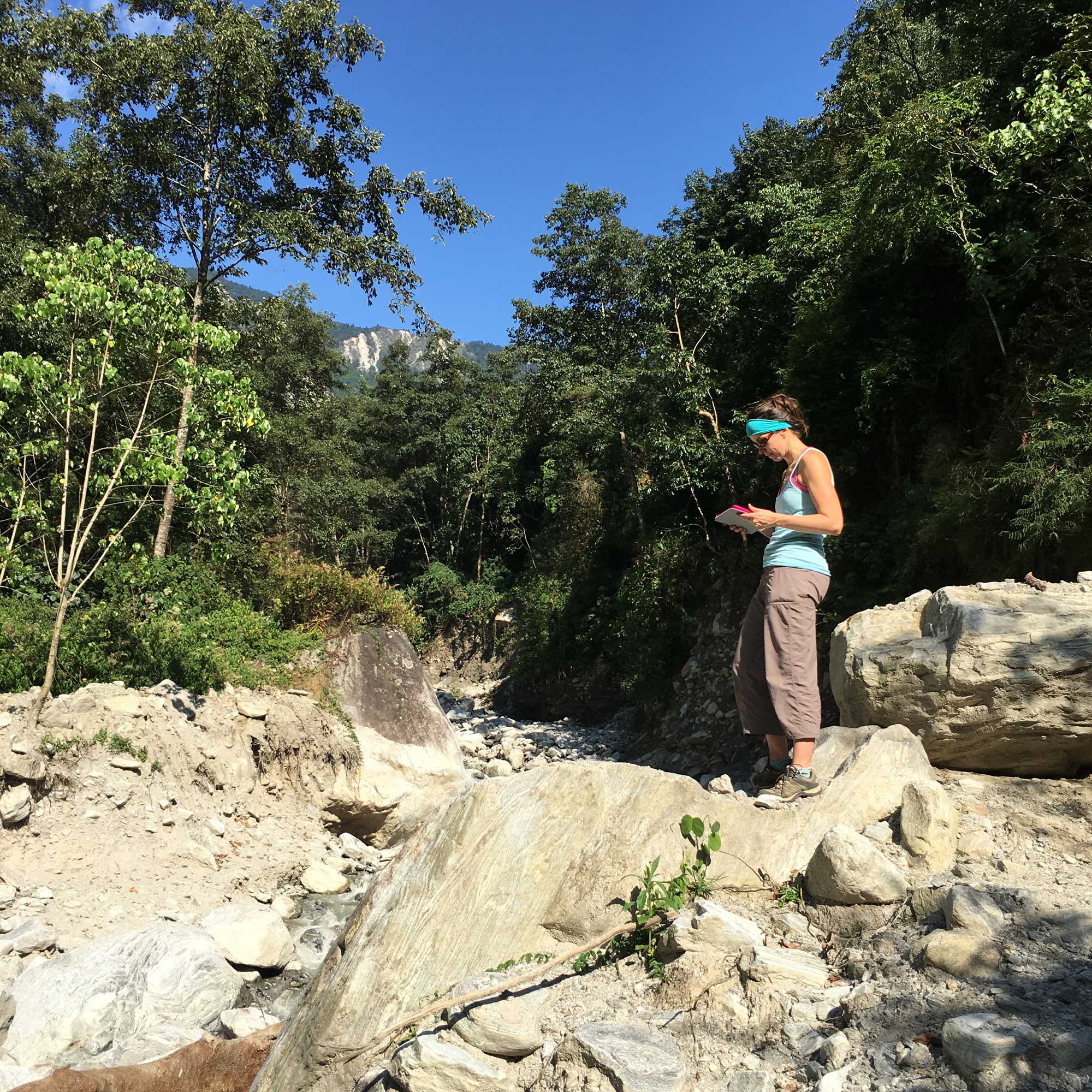 Marin Clark assessing boulders deposited during a monsoon-triggered debris flow near  Timbu, Nepal. Image credit: Dimitrios Zekkos