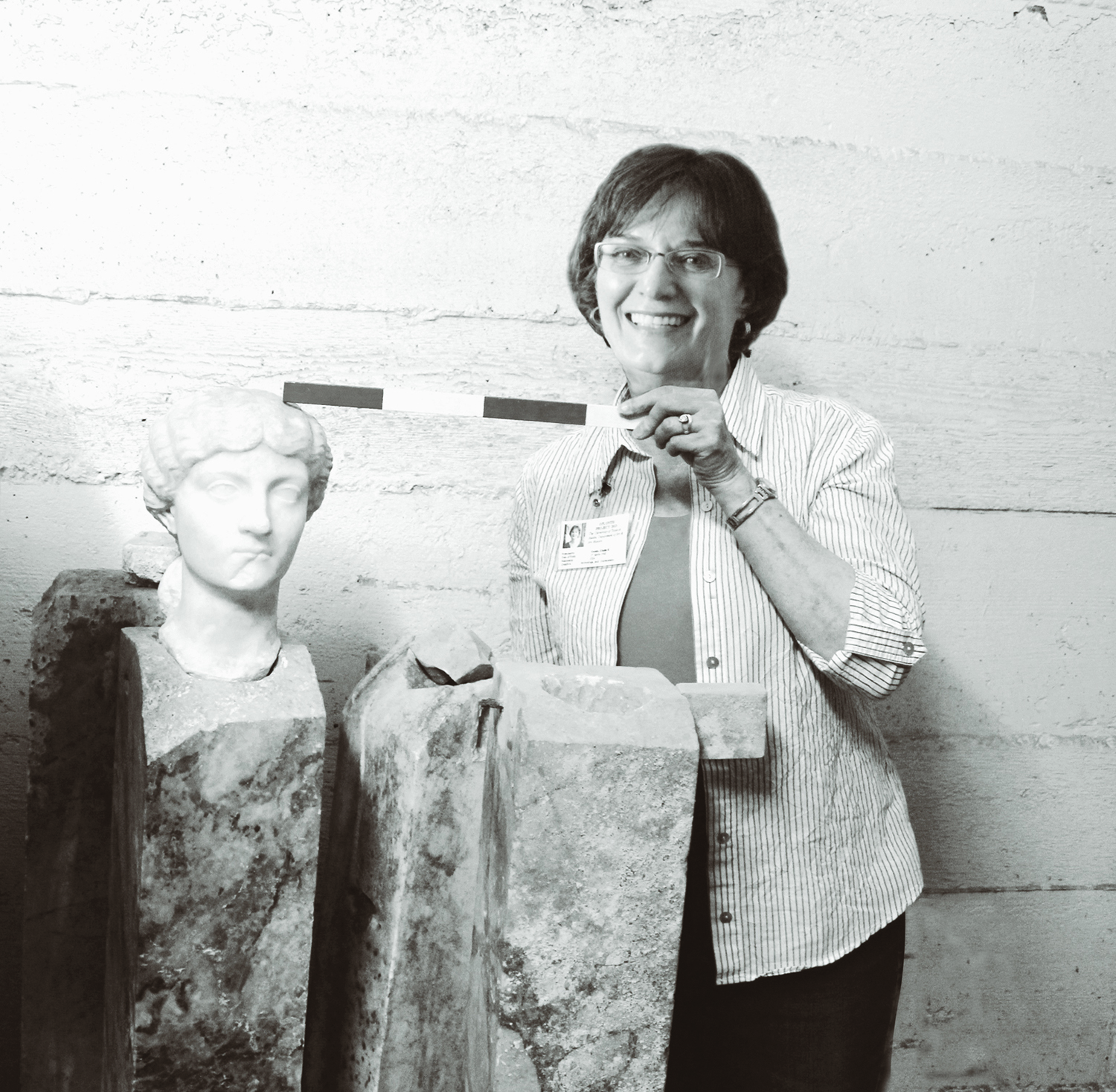 Elaine Gazda pauses while&nbsp;working&nbsp;at&nbsp;Oplontisin the storeroom of the dig.&nbsp;The marble portrait in the photo is now on view as part of the&nbsp;“Oplontis” exhibition at the Kelsey Museum of Archeology. Image courtesy Kelsey Museum of Archeology