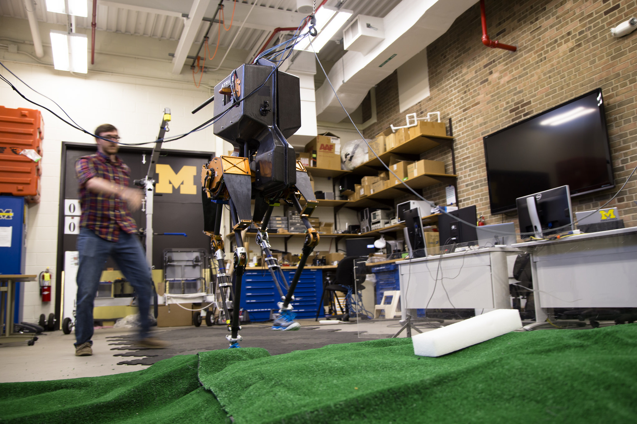 MARLO, the 3D bipedal robot that belongs to electrical engineering professor Jessy Grizzle and his team of students, is starting to really figure out this walking thing. Here, robotics PhD student Ross Hartley watches as MARLO demonstrate's her ability to conquer tough terrain. Image credit: Evan Dougherty, Michigan Engineering