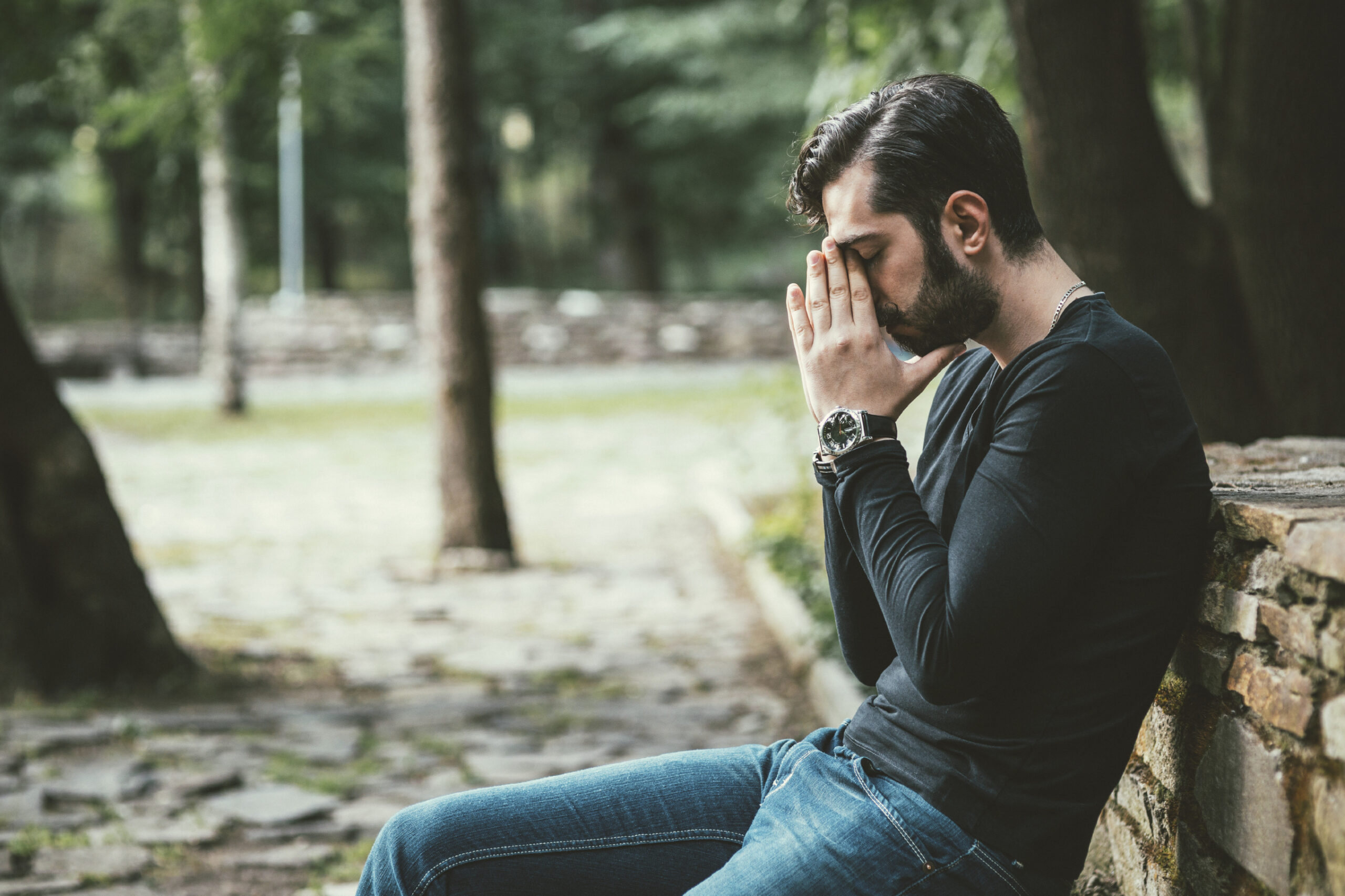 A middle-aged white man with his head in his hands. (stock image)
