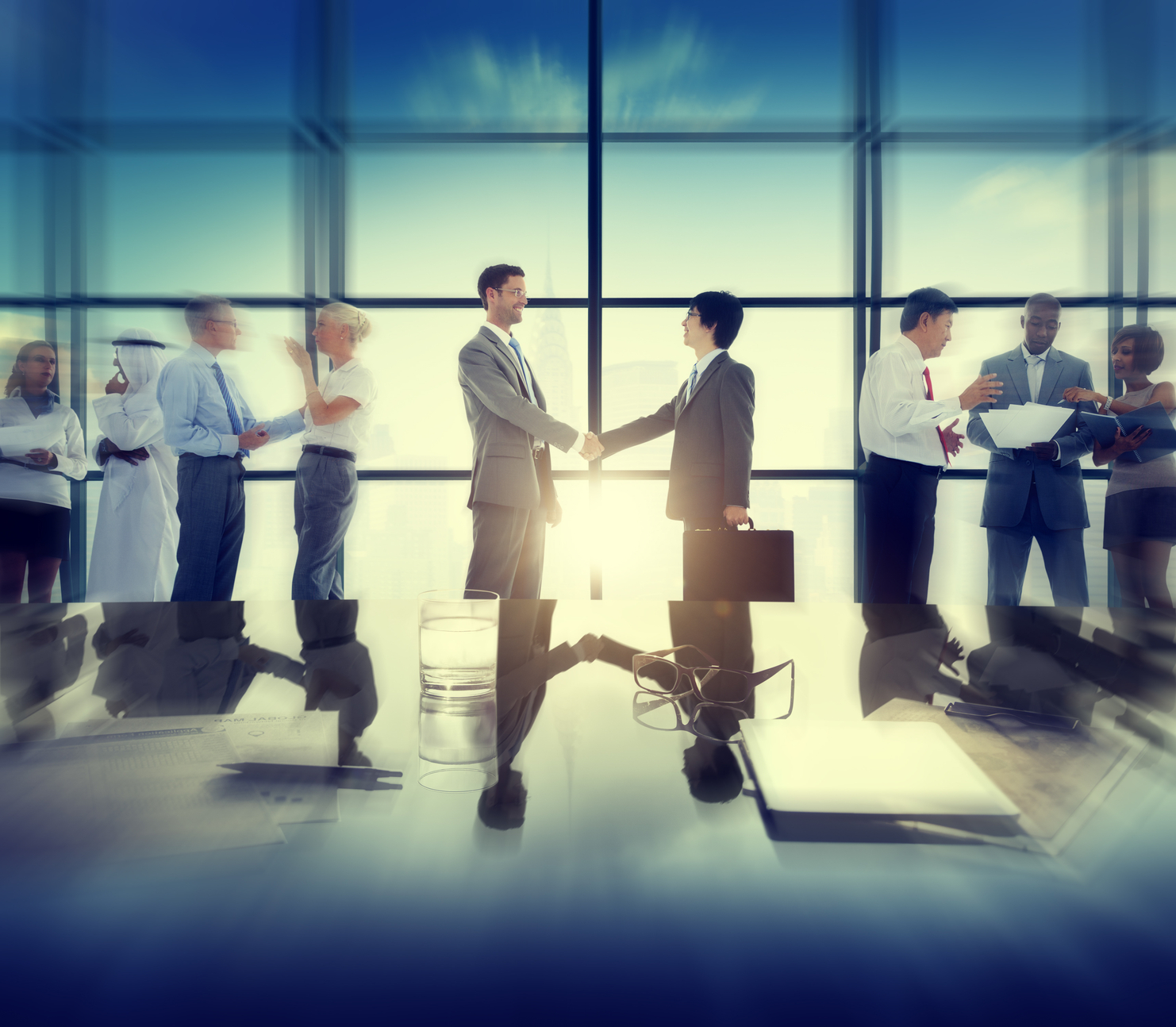 Group of business people and men handshake reflected onto table. (stock image)