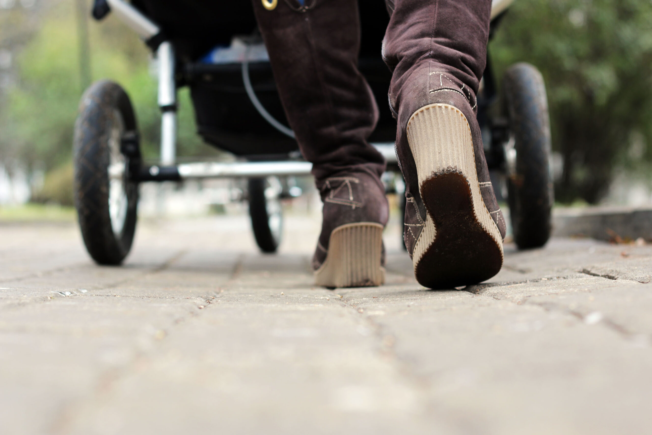 Street view of woman walking with stroller. (stock image)
