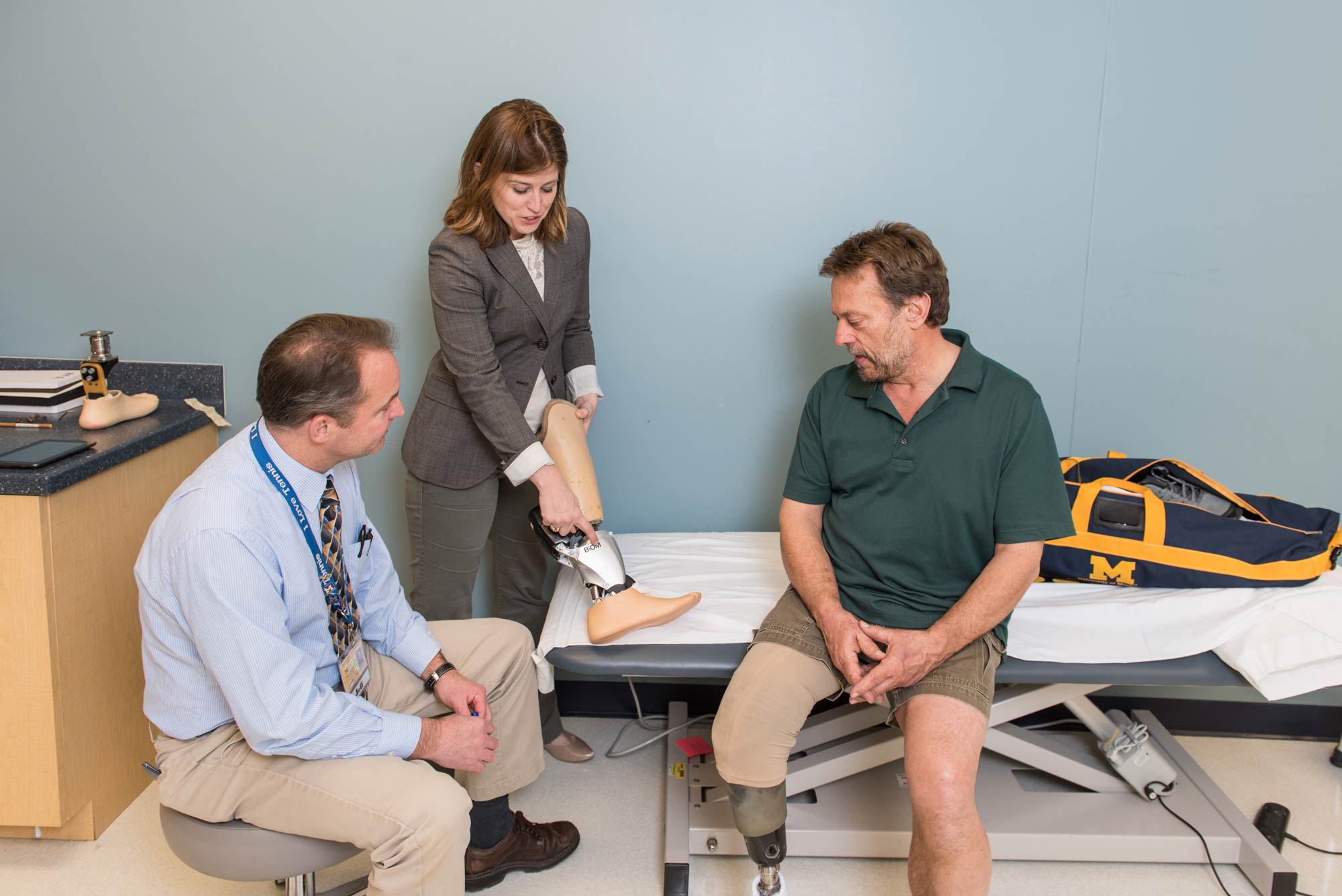 Jeffrey Wensman and Deanna Gates, assistant professor, Director of the Rehabilitation Biomechanics Laboratory at the University of Michigan help fit Roger Schulte (right) with a prosthesis. Image credit: Scott C. Soderberg, Michigan Photography