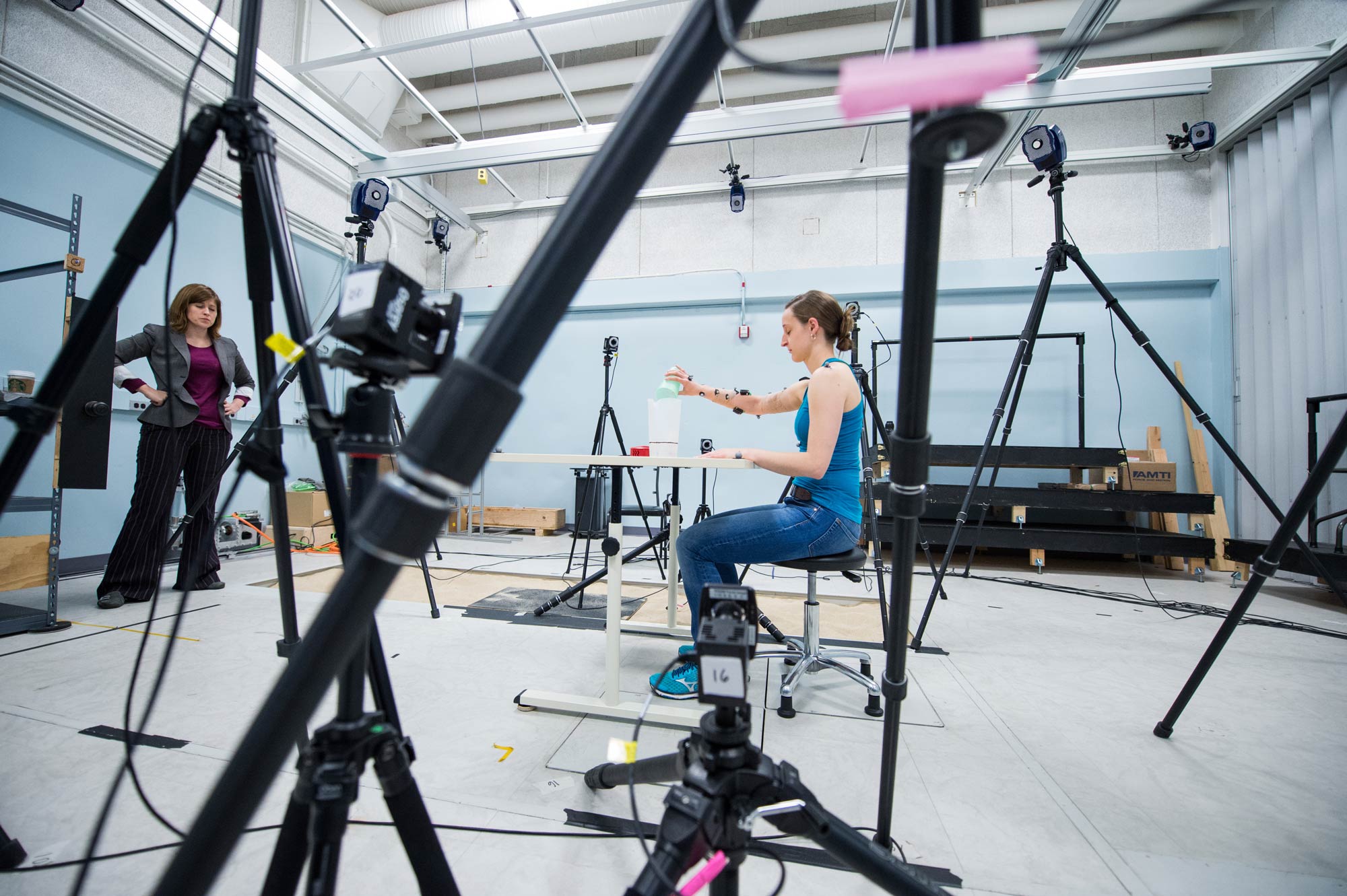 Deanna Gates, director of the Rehabilitation Biomechanics Laboratory at the University of Michigan observes as participant Kali Almdale pours a glass of water. They’re recording Almdale’s wrist movements using sensors. Image credit: Austin Thomason, Michigan Photography