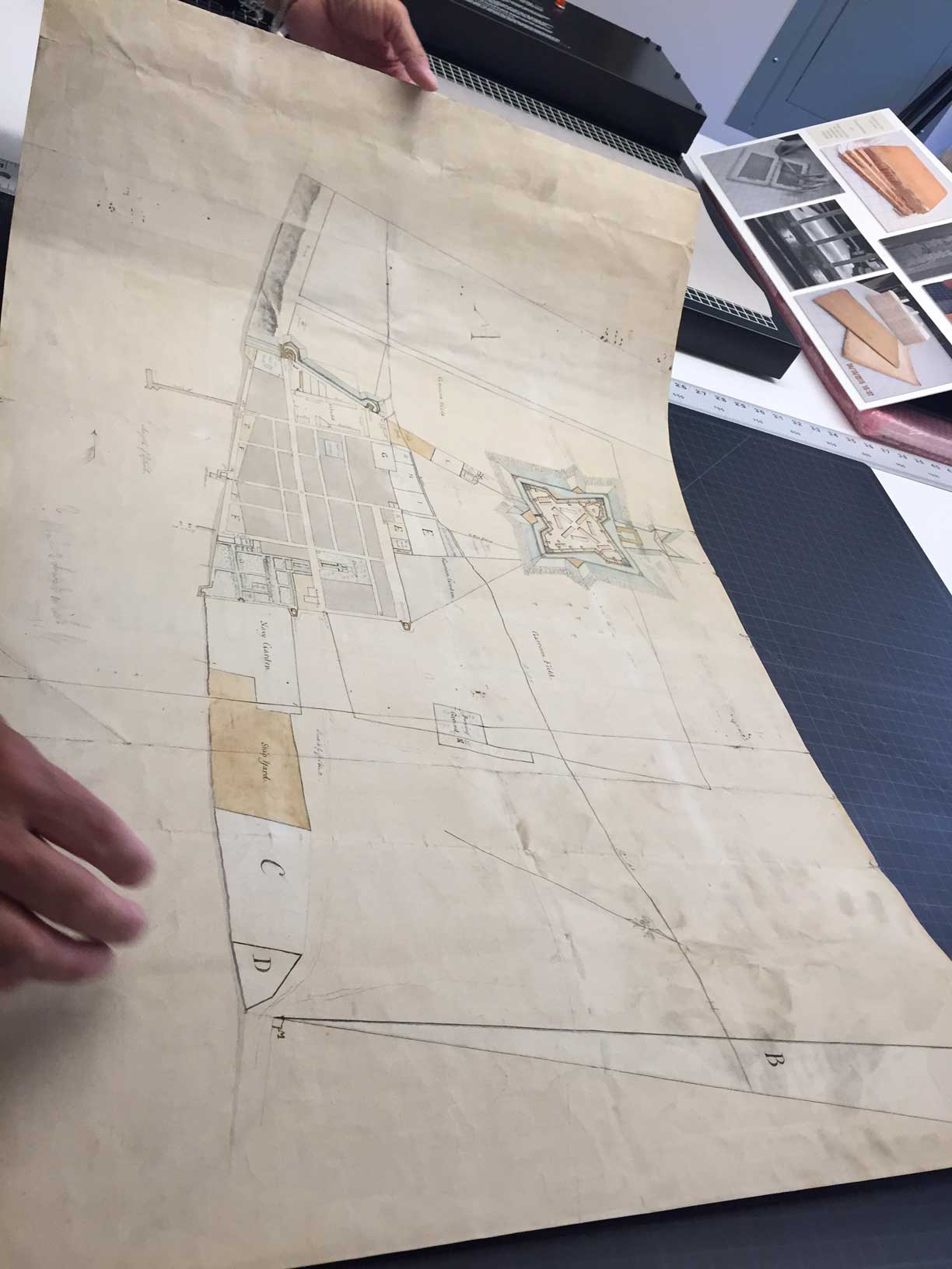 "Rough sketch of the King's Domain at Detroit," a 1790 manuscript plan of the city of Detroit, was discovered in a family home in Almonte, Canada. Here archivists inspect the work for the first time outside of its original frame. Image courtesy: William L. Clements Library