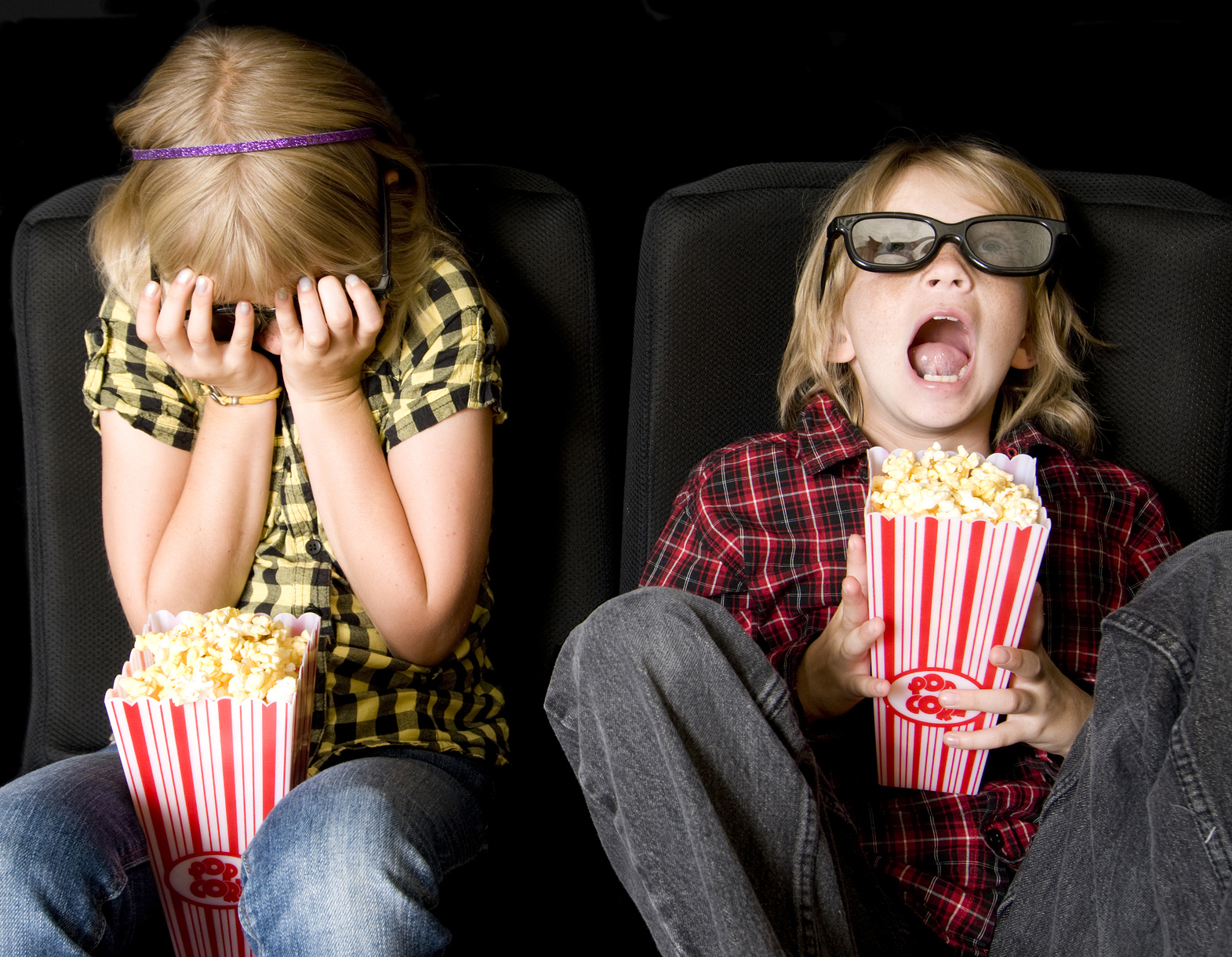 Two young girls watching a scary movie. (stock image)