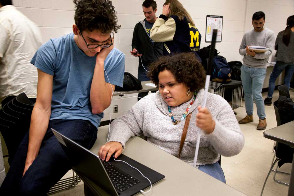 India West discusses a project that is designed to teach coding to blind students with a computer science and engineering student Gabriel Pascualy who helped create it. Photo by Marcin Szczepanski 