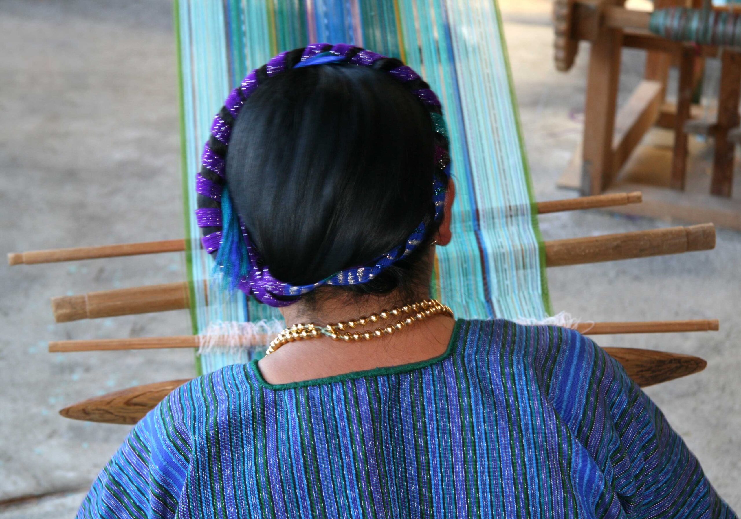 Mayan woman weaving on a traditional backstrap loom in village by the lake Atitlan, Guatemala. (stock image)
