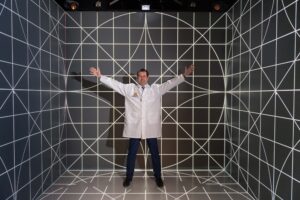 Alex DaSilva, assistant professor in the University of Michigan School of Dentistry, standing in the 3D lab on North Campus. DaSilva uses 3D imaging of the brain to better understand what happens to brain chemicals during a migraine headache. The formal name for the 3D lab is the Michigan Immersive Digital Experience Nexus, or MIDEN. Image credit: Scott Soderberg, Michigan Photography