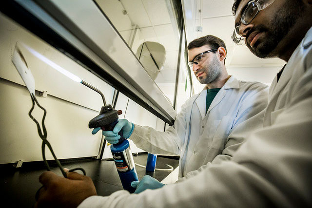 Mathew Boban, Macromolecular Science & Engineering PhD Student, and Kevin Gloving, Materials Science & Engineering PhD Student, test a superhydrophobic surface by burning it as part of its resistance testing against water in the NCRC on March 28, 2017. Photo: Joseph Xu/Multimedia Content Producer, University of Michigan - College of Engineering