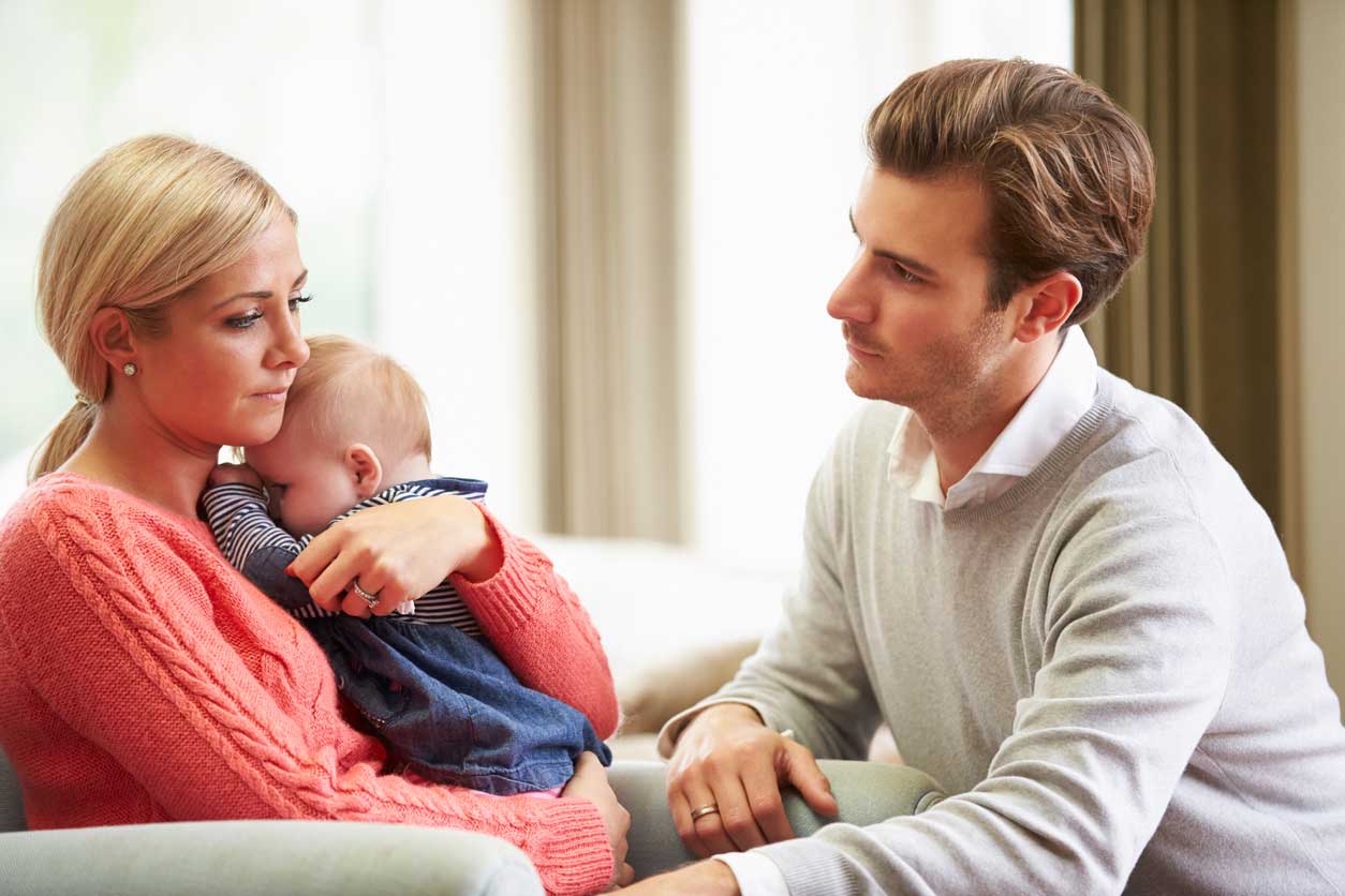 Young couple with baby looking sad. (stock image)