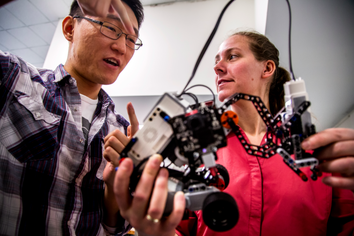 Ding Zhang, ME PhD Student, and Kira Barton, ME Professor, discuss results from a recent test of a robot that uses cooperative algorithms in the HH Dow Building on March 9, 2015. The robot interacts with other robots that are installed with cooperative algorithms that Kira Barton and her research group have designed in hopes of providing a model for larger scale implementation of autonomous vehicles and robots. Image credit: Joseph Xu, Michigan Engineering Communications & Marketing