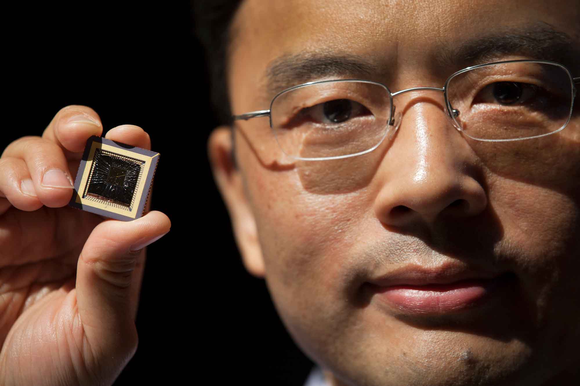 Wei Lu, Professor of Electrical Engineering & Computer Science at the University of Michigan holds a memristor chip he created.