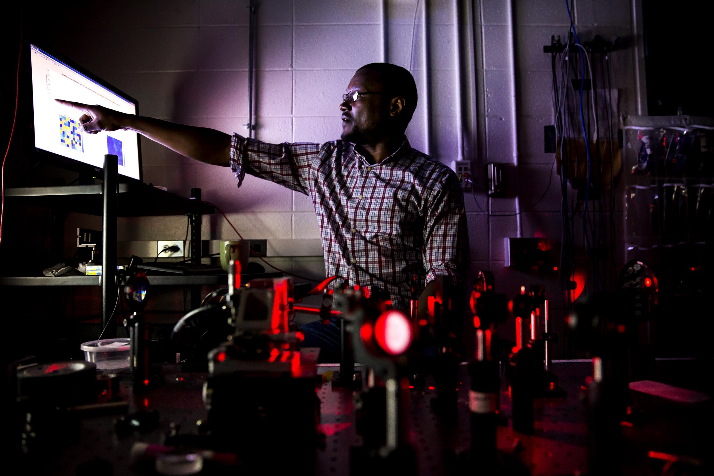 Moussa N'Gom points to a display showing how the yogurt scatters light. He hopes that the speedy algorithm developed by his team is another step toward medical imaging that can see through skin with visible light. Image credit: Joseph Xu, Michigan Engineering