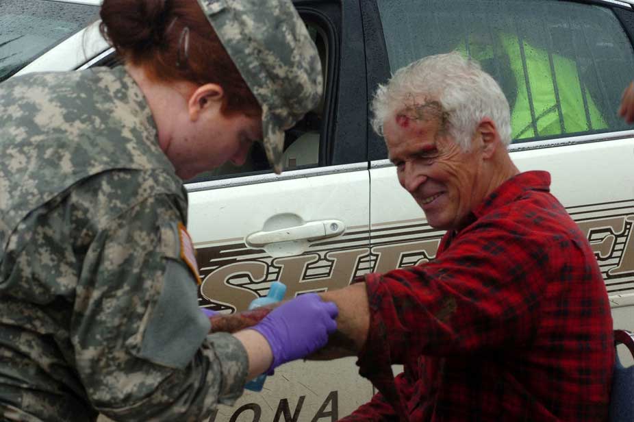 U.S. Army Spc. Pam Anderson applies first-aid medical attention to an elderly man during flood relief operations just outside of Winona, Minnesota, August 20, 2007. Image credit: Staff Sgt. Daniel Ewer, U.S. Army