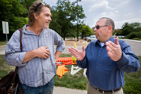 Philip Stewart, Pinwheel artist, speaks with John Keedy, CoE Facilities Director, speak outside before the installation of the sculpture "3 Cubes In A Seven Axis Relationship". Image credit: Joseph Xu, Michigan Engineering