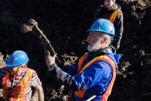 Fisher holding an intact mammoth rib collected at James Bristle’s farm near Chelsea on Nov. 29, 2017.