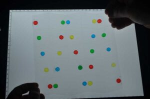 Charge-selective (yellow and green) and freshwater and saline (blue and red) hydrogels, printed on a sheet that has been laser-cut in a Miura fold pattern. IMAGE: Biophysics group, Adolple Merkle Institute
