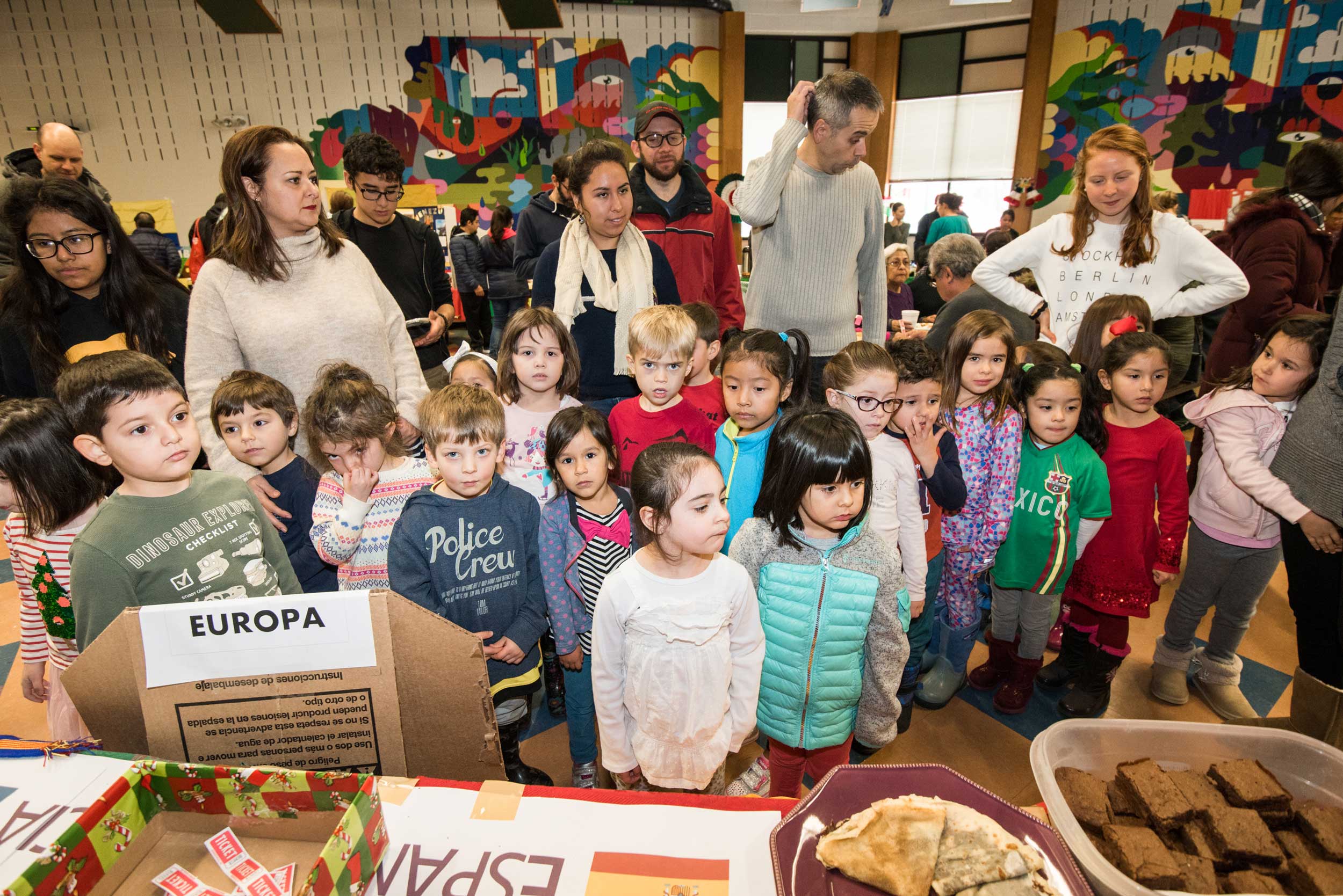 En Nuestra Lengua students line up as they make their way through the Bach Elementary cafeteria during the program’s annual fundraiser that includes sales of traditional foods from Spanish-speaking countries.