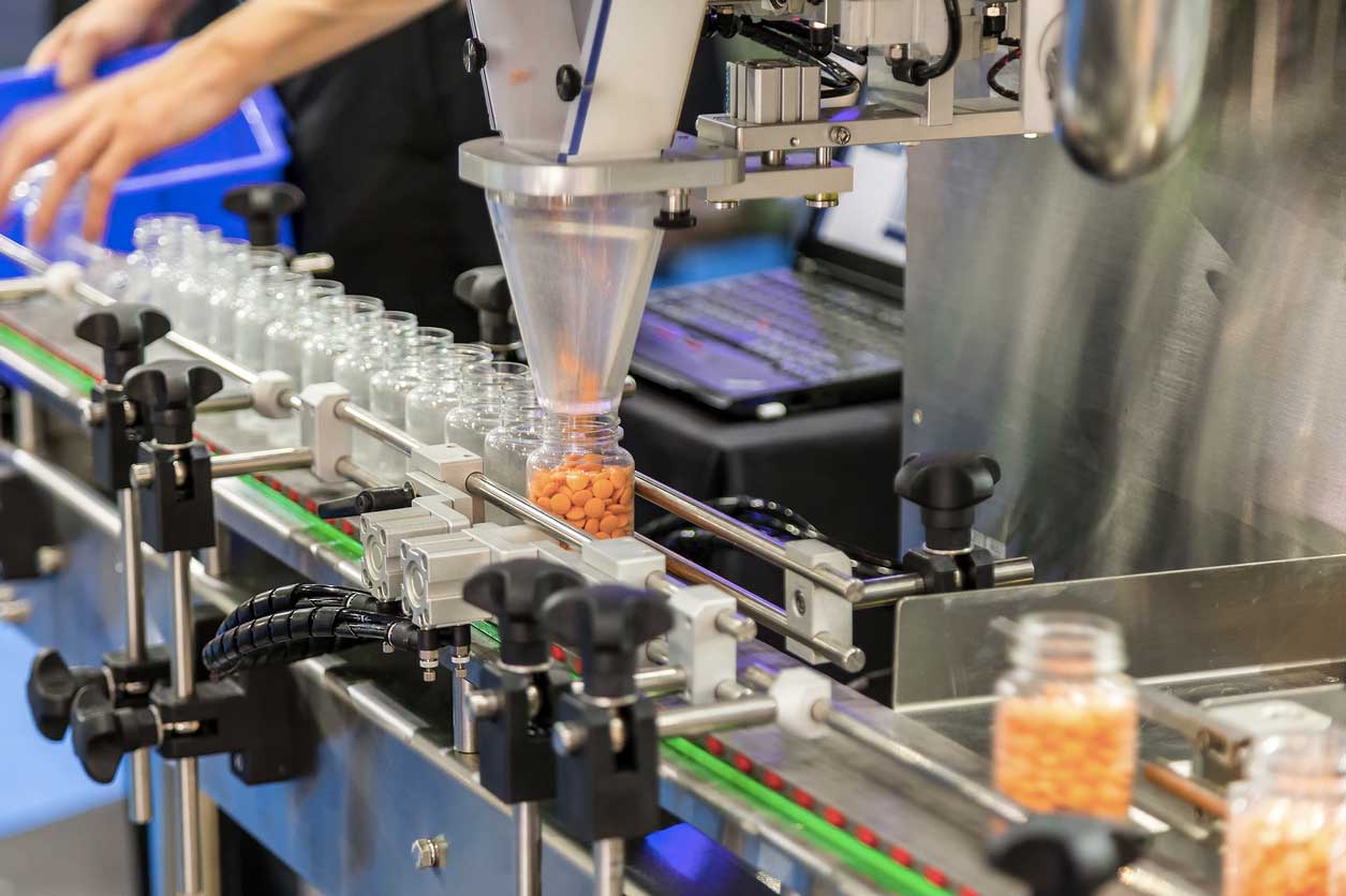 Tablet / Capsule counting machine conveyor in production line of pharmaceutical industry. (stock image)